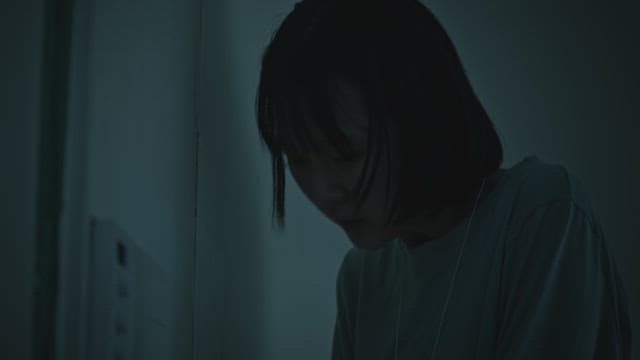 어두운 방에서 숨을 몰아쉬며 천식용 호흡기를 들이마시는 여자