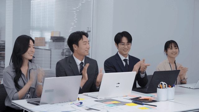 회의실에서 박수치는 동료들