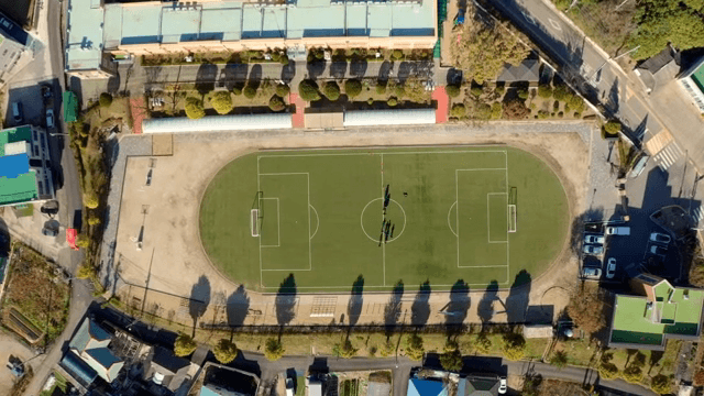 학교 축구장에서 학생들이 운동하는 모습