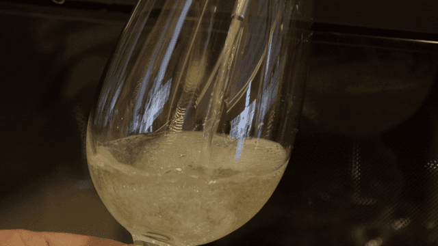 Scene of pouring white wine into wine glass