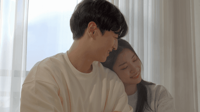 Couple resting together by sunlit window