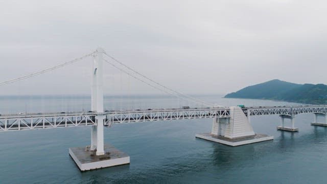 바다 위에 놓인 긴 다리와 도시 스카이라인