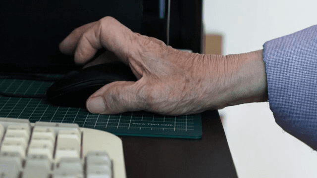 컴퓨터 마우스를 사용하는 노인의 손