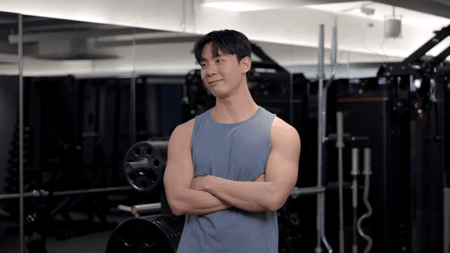 헬스장에서 자신감 있게 서있는 젊은 남성의 옆모습