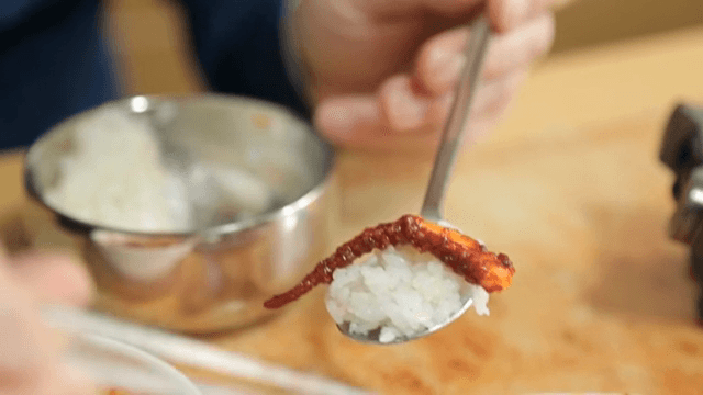 밥에 오징어볶음을 올리는 모습