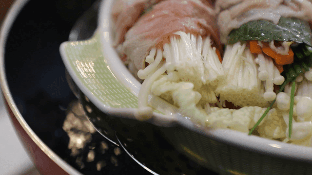 Steamed vegetable and meat rolls over boiling hot water