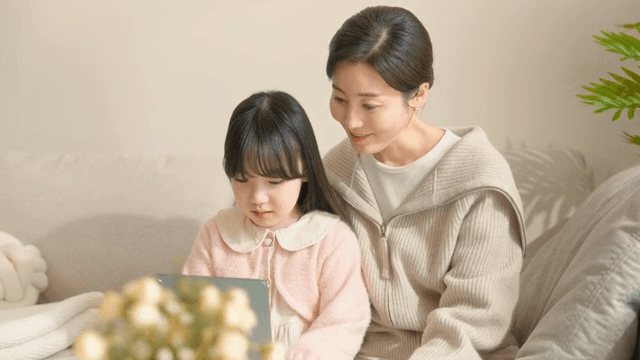 엄마와 딸이 함께 태블릿을 사용하는 모습
