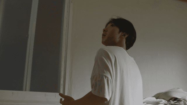 어두운 방에서 위를 바라보는 남자