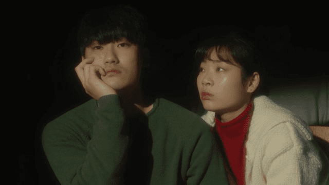 어두운 조명 속에 앉아 있는 커플