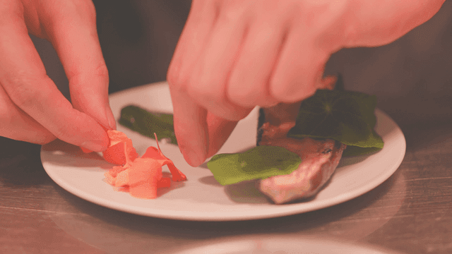 Grilled eggplant dish garnished with fresh leaves