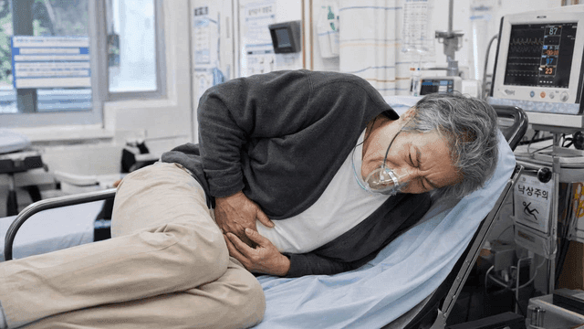 Elderly emergency patient in hospital wearing oxygen mask