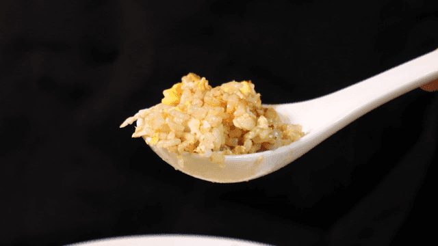 Spoonful of fried rice with egg.