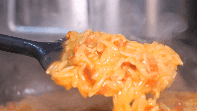Steaming pasta being stirred in a pot