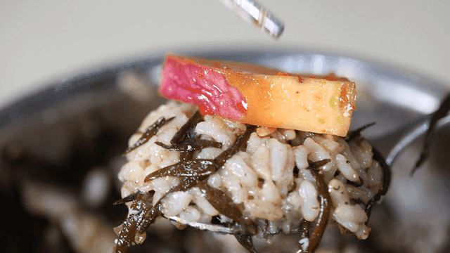 Stone pot rice topped with tofu and cubed radish kimchi