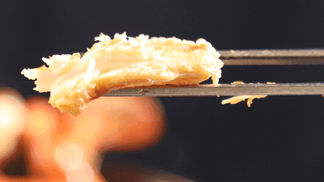 Chopsticks holding a piece of crab meat