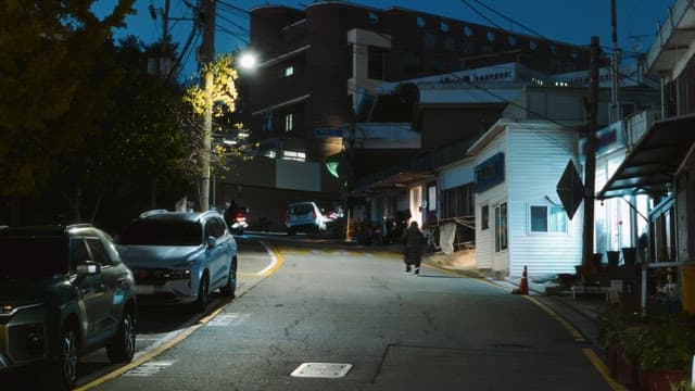 주차된 자동차와 보행자가 있는 거리