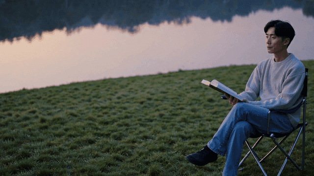 A man gazing into the distance by a tranquil lakeside