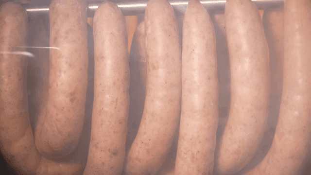 오븐 안 훈제통 불 위에서 훈제되는 소시지