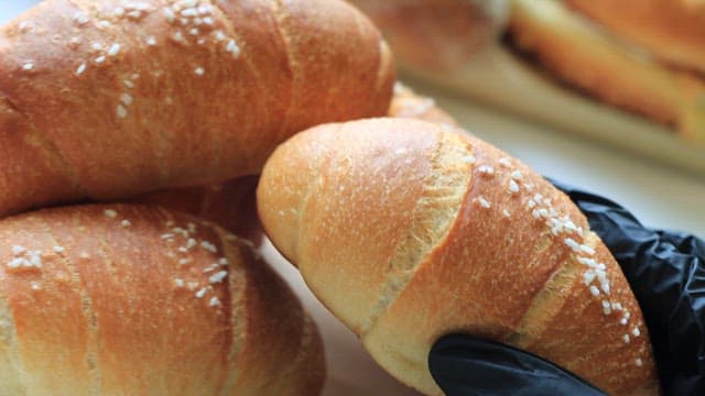 Hand holding a freshly baked salted butter rolls