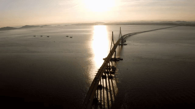 Long bridge over a calm sea at sunset