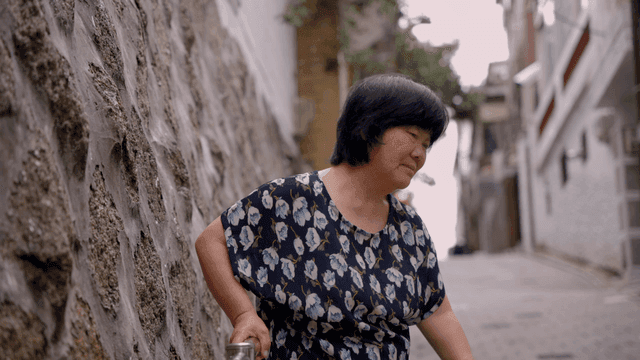 난간에 기대어 쉬는 노인 여성