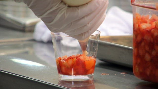 과일 컵에 휘핑크림을 추가하는 장면