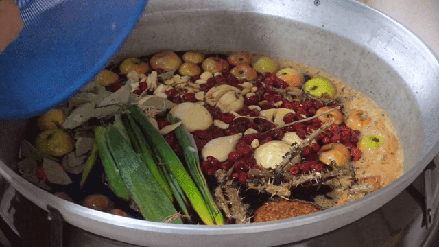 Pot filled with soy sauce, spices, and vegetables