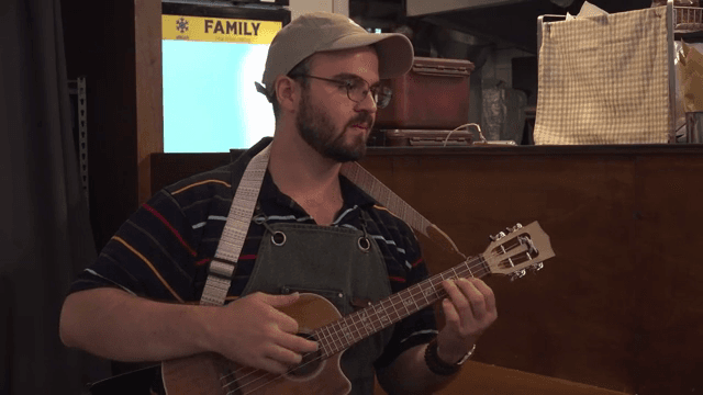 아늑한 실내에서 우쿨렐레를 연주하는 남자