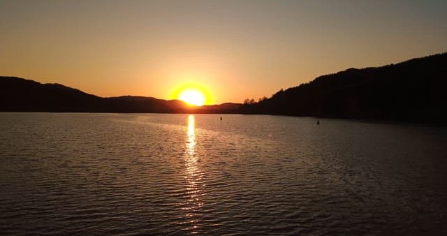 Sunset over a serene lake with mountains