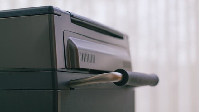 트레이 손잡이를 밀고 가는 노란 옷의 사람