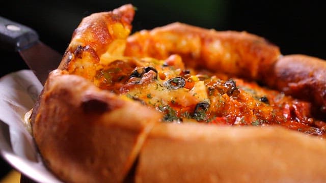 녹아내리는 치즈가 있는 시카고 피자 조각