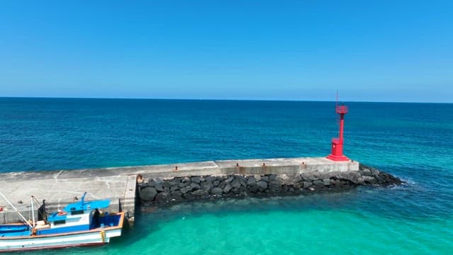 Red lighthouse on a clear blue sea