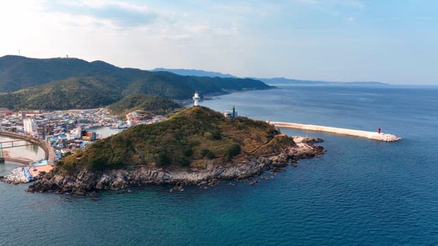 Coastal town with a lighthouse on a hill