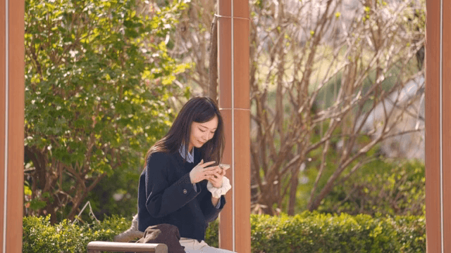 공원 벤치에 앉아 셀카를 찍는 여성