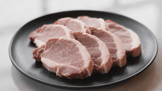 Sanitary pork neck slices on black plate