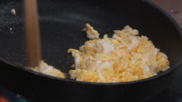 Cooking Scrambled Eggs and Green Onions in a Frying Pan