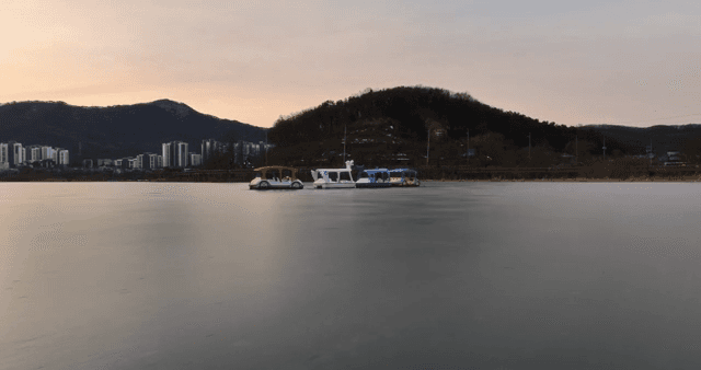 일몰에 페달 보트가 있는 고요한 호수