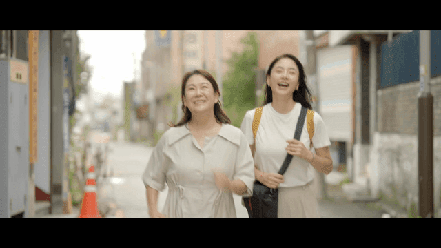 Two women happily running on street