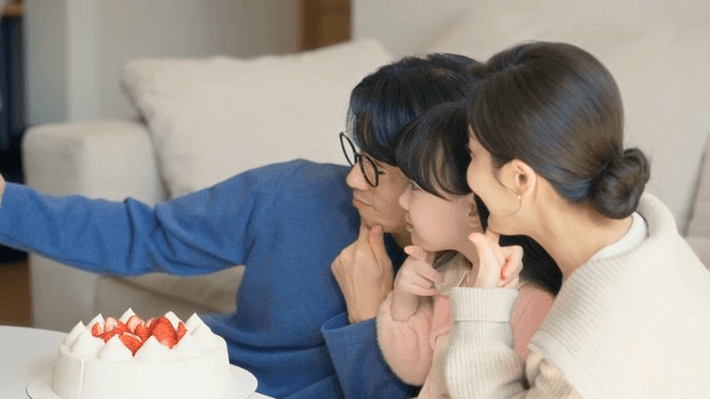 Family posing with cake indoors
