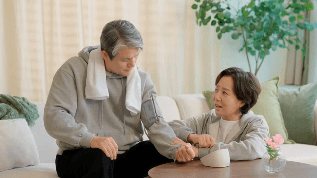 집에서 혈압을 측정하는 노부부