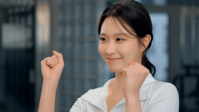 미소 지으며 주먹을 쥐고 응원하는 젊은 여성