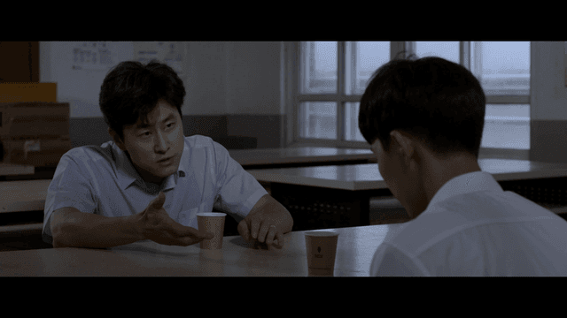 음료를 마시며 진지하게 대화 중인 학생과 교사