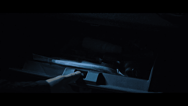 Hand takes pistol out of car's glove compartment.