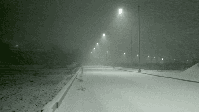 Snow-covered road with streetlights