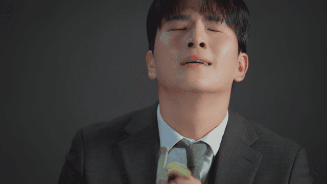 정장을 입은 남자가 돈다발을 냄새 맡는 모습