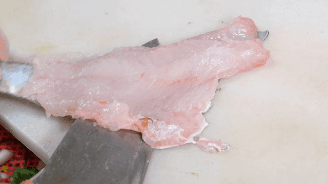 Knife that fillets fish on cutting board