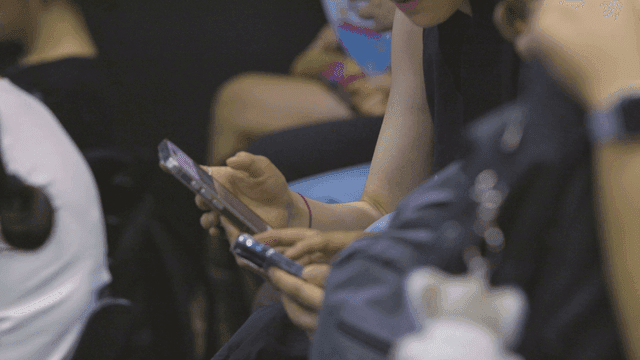 People gathered together looking at their smartphones