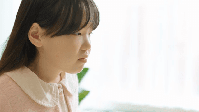 실내에서 분홍 스웨터를 입은 어린 소녀