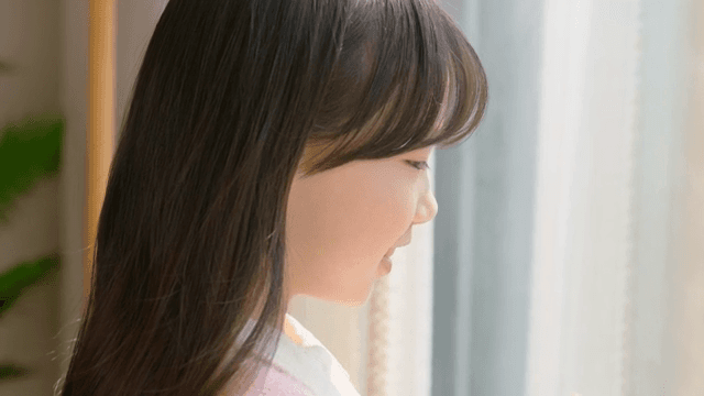 Child looking out the window and waving their hand
