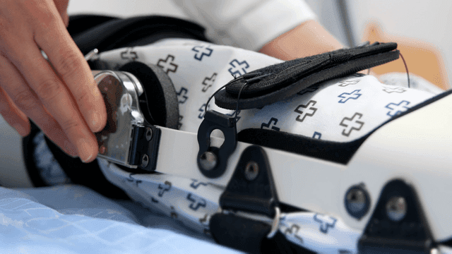 Adjusting a medical brace on a bed